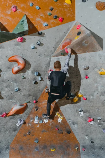 Duvara tutunarak tırmanan adam.