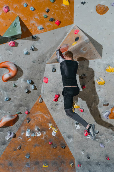 Man climbing wall with grips