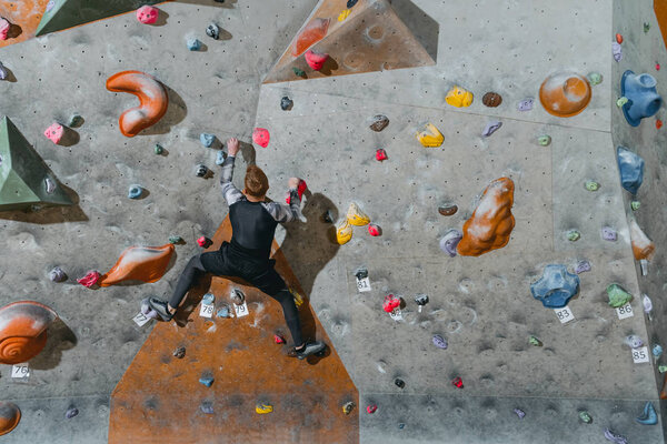 Man climbing wall with grips