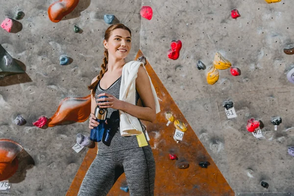 Sportive kobieta przed ścianą wspinaczkową — Zdjęcie stockowe