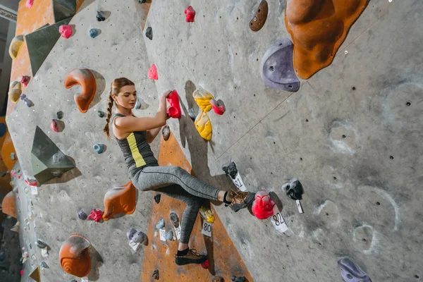 Parete da arrampicata donna con impugnature — Foto Stock