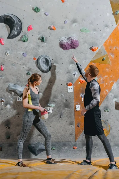 Young man pointing to climbing wall — Stock Photo, Image