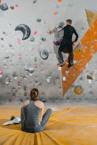 Giovane arrampicata su parete con impugnature — Foto Stock