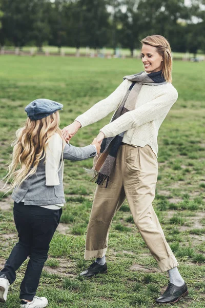 Mor och dotter höll händer och spinning — Gratis stockfoto