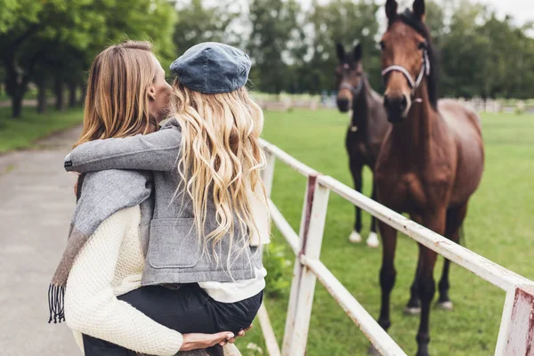 Mãe e filha em paddock com cavalos — Fotografia de Stock