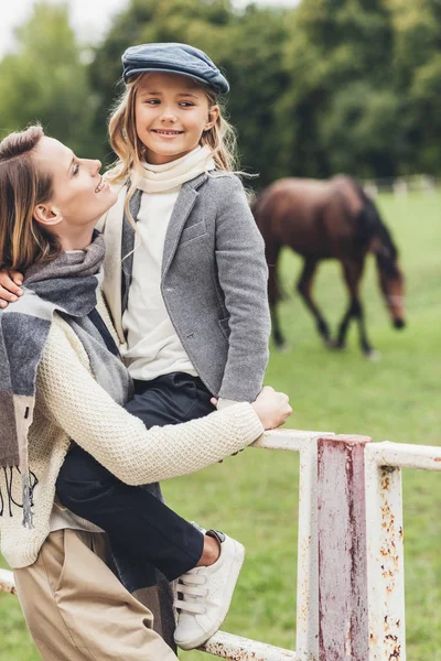 Lycklig familj på paddock med häst — Stockfoto