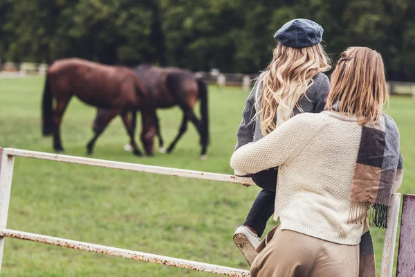 Mother and daughter at paddock with horses — Stock Photo, Image