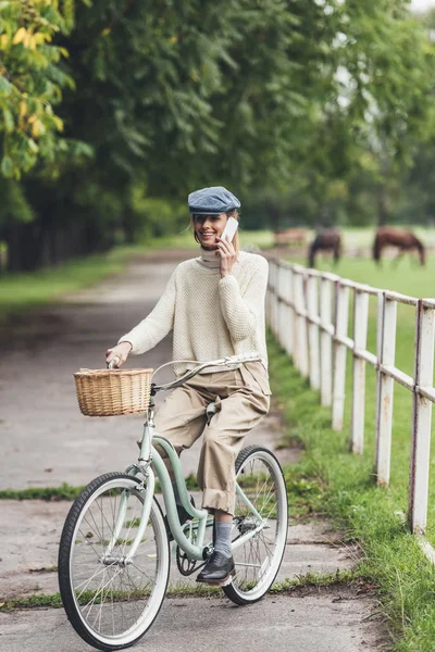 Woman with smartphone on bicycle — Stock Photo, Image