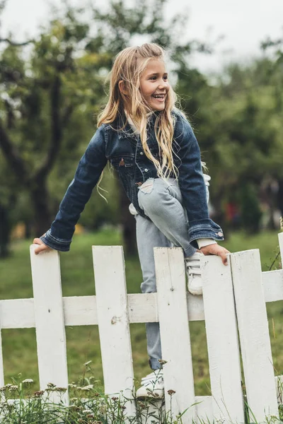 Kind klettert über Zaun — Stockfoto
