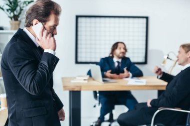 smartphone üzerinde konuşan işadamı