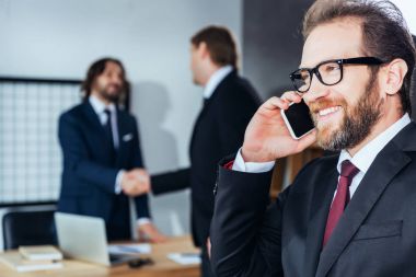 smartphone üzerinde konuşan işadamı