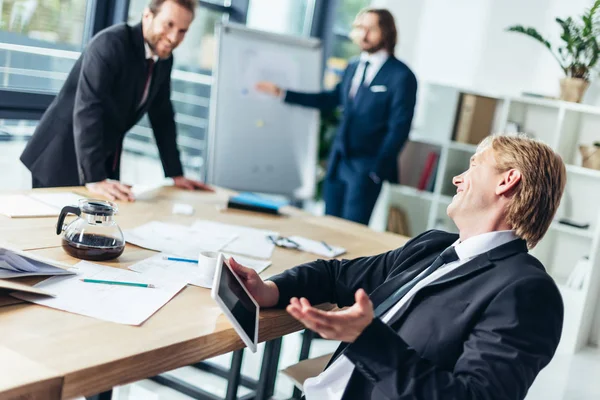 İş adamları ofiste konuşuyor.