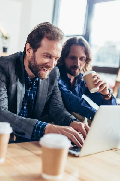 dizüstü bilgisayar kullanan işadamları