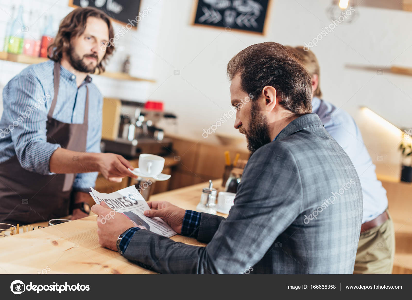 Businessman reading newspaper in cafe — Stock Photo