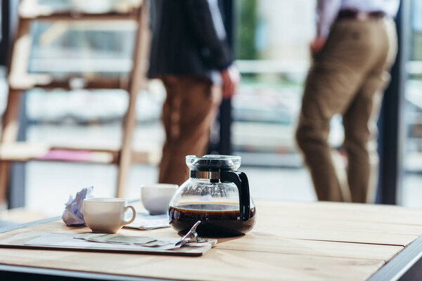coffee, money and newspaper on table