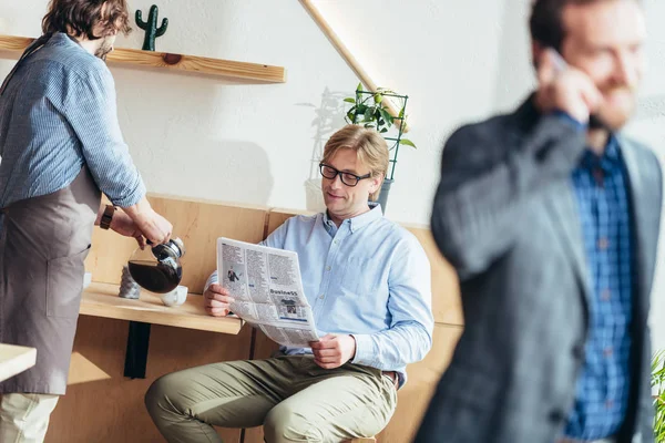 Hombre de negocios con periódico en la cafetería — Foto de stock gratis