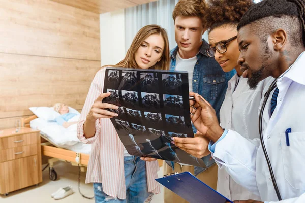 Lékaři a pacienti zkoumání X-ray — Stock fotografie