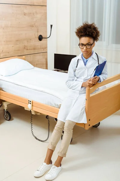 Doctor sitting on hospital bed — Free Stock Photo