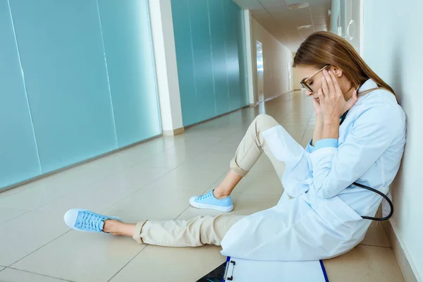 Лікар сидить в лікарняному коридорі — стокове фото