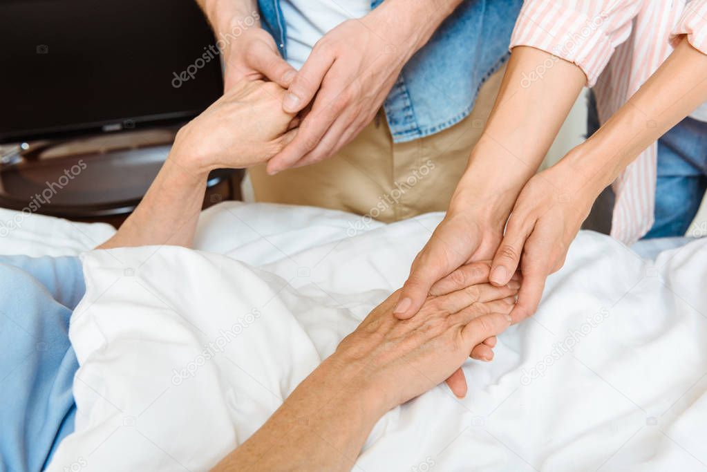 Young people holding elderly hands