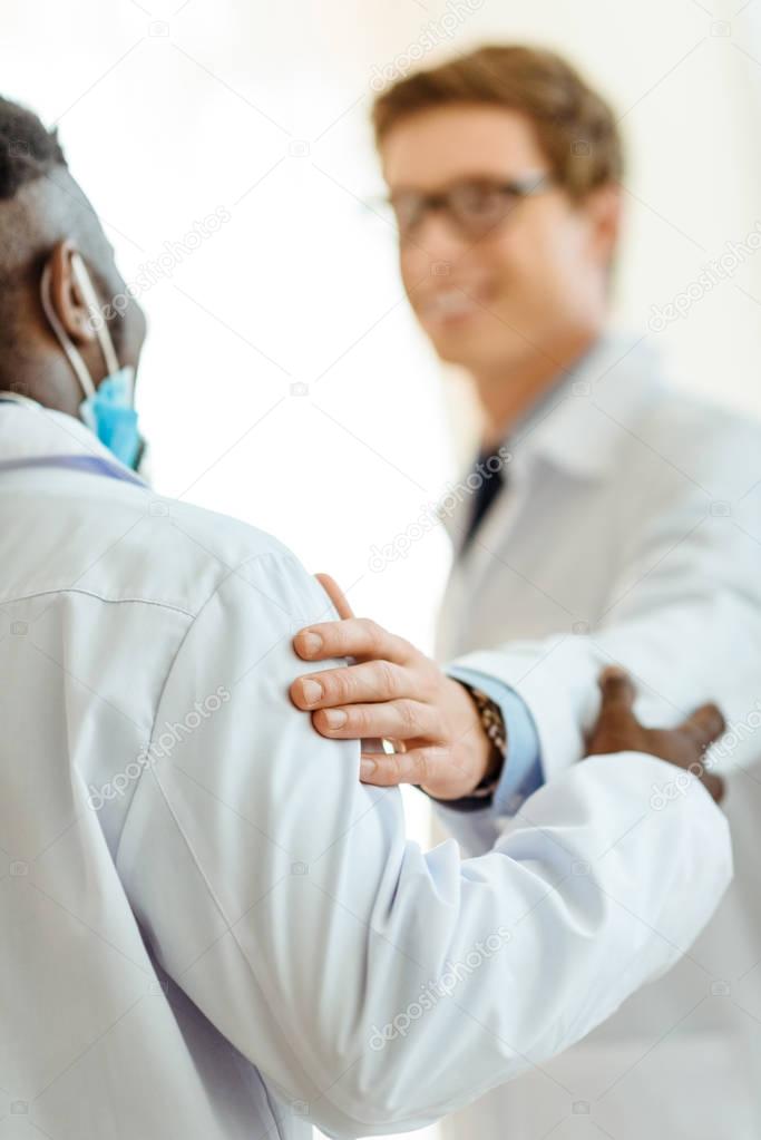 doctor patting colleague on shoulder