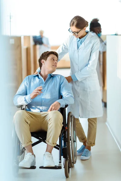 Doctor ayudando a hombre discapacitado en el hospital — Foto de Stock