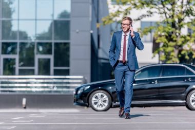 Takım elbiseli bir işadamı akıllı telefon kullanıyor.