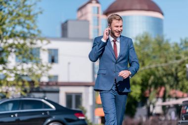 Takım elbiseli bir işadamı akıllı telefon kullanıyor.  
