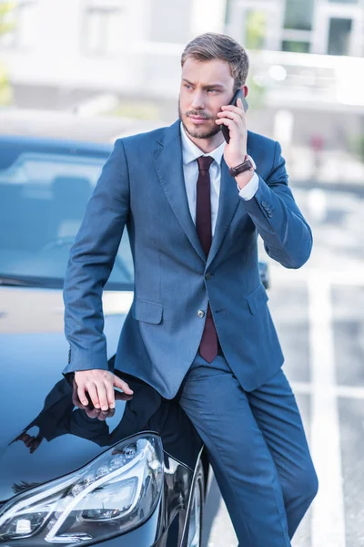 Podnikatel s smartphone na auto — Stock fotografie