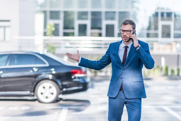 Geschäftsmann mit Smartphone auf Parkplatz — Stockfoto