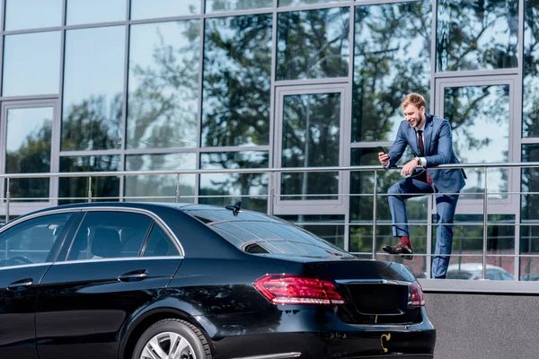 Businessman with smartphone at office building — Stock Photo, Image