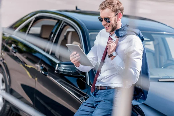 Hombre de negocios con tableta en el coche — Foto de Stock