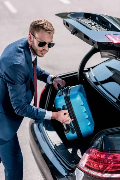 Geschäftsmann mit Koffer am Auto — Stockfoto