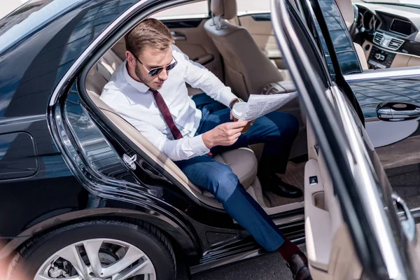 Hombre de negocios con periódico en el asiento trasero —  Fotos de Stock