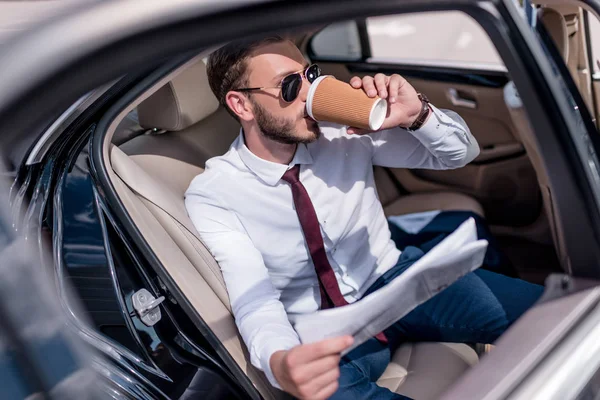 Businessman drinking coffee in car — Stock Photo, Image