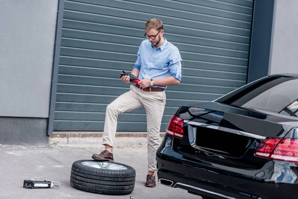 Uomo che cambia pneumatico auto — Foto Stock