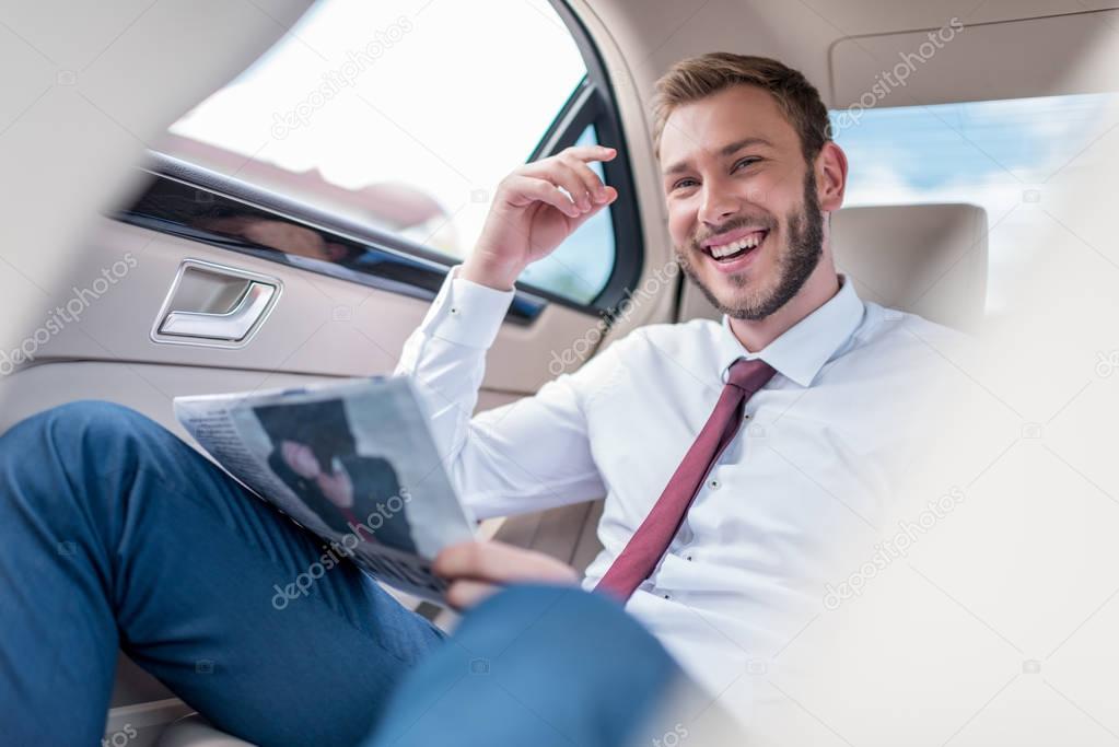 man with newspaper on backseat