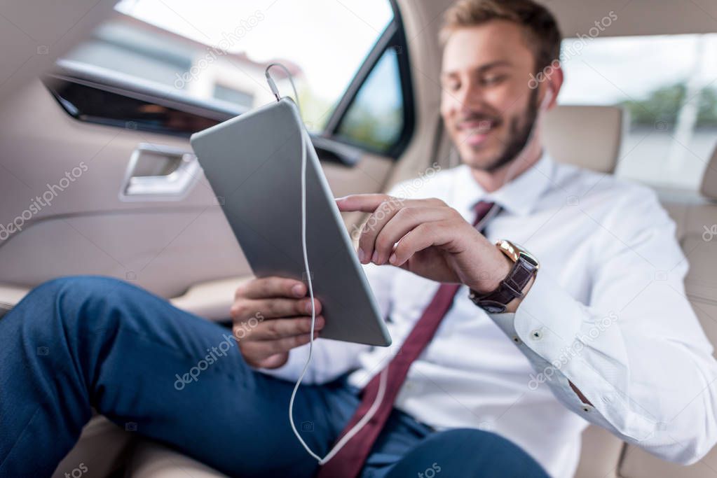 man with digital tablet in car