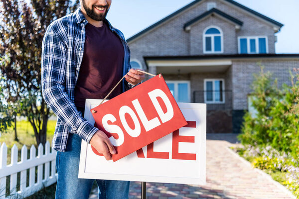 man hanging sold sign