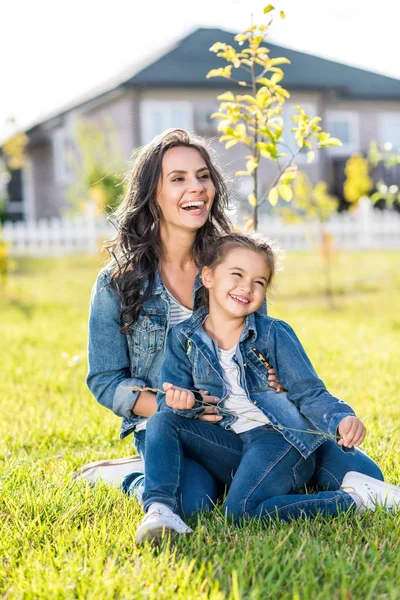 Mor och dotter sitter på gräset — Stockfoto