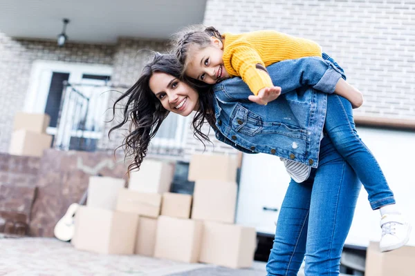 Filha piggyback equitação mãe — Fotografia de Stock