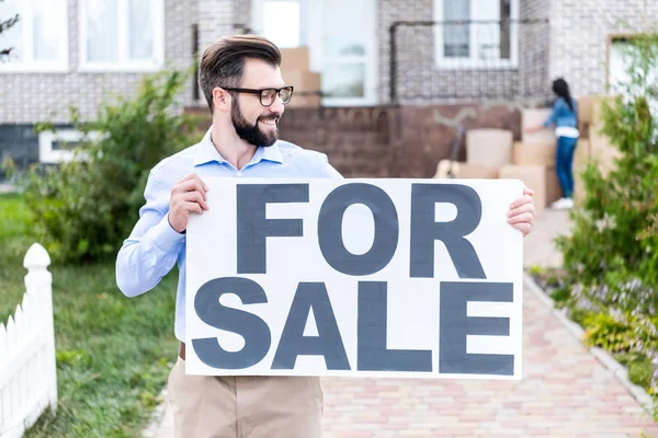 Realtor with banner for sale — Stock Photo, Image