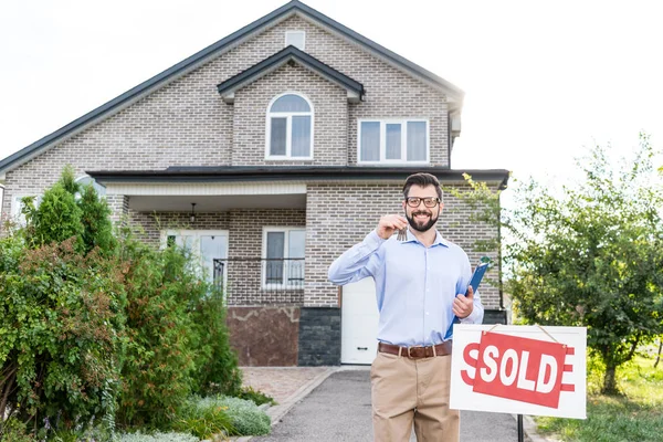 Makelaar met toetsen van verkochte huis — Stockfoto