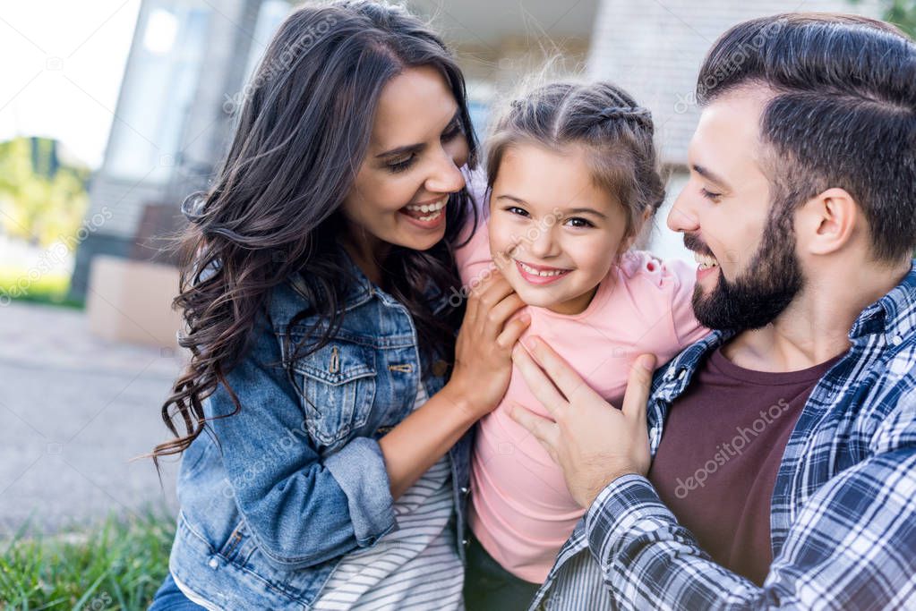 Family having fun together outdoors while sitting on grass