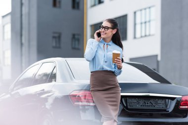 businesswoman talking on smartphone with coffee