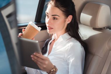 Dijital tablet ve kahve ile araba kadında