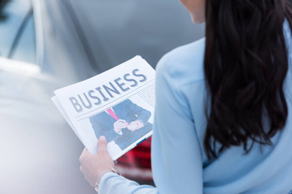 Woman holding business newspaper