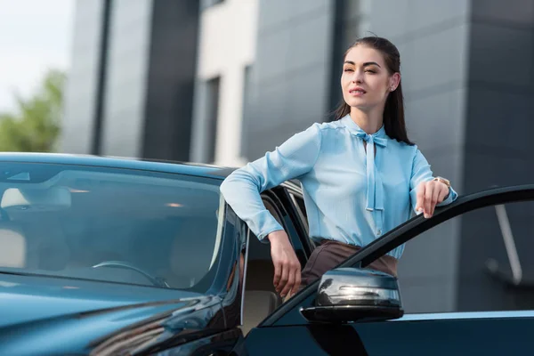 Businesswoman leaning on car — Stock Photo, Image