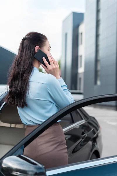 Businesswoman talking on smartphone near car — Stock Photo, Image