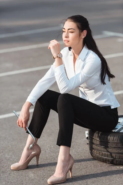 Mulher sentada no pneu do carro — Fotografia de Stock